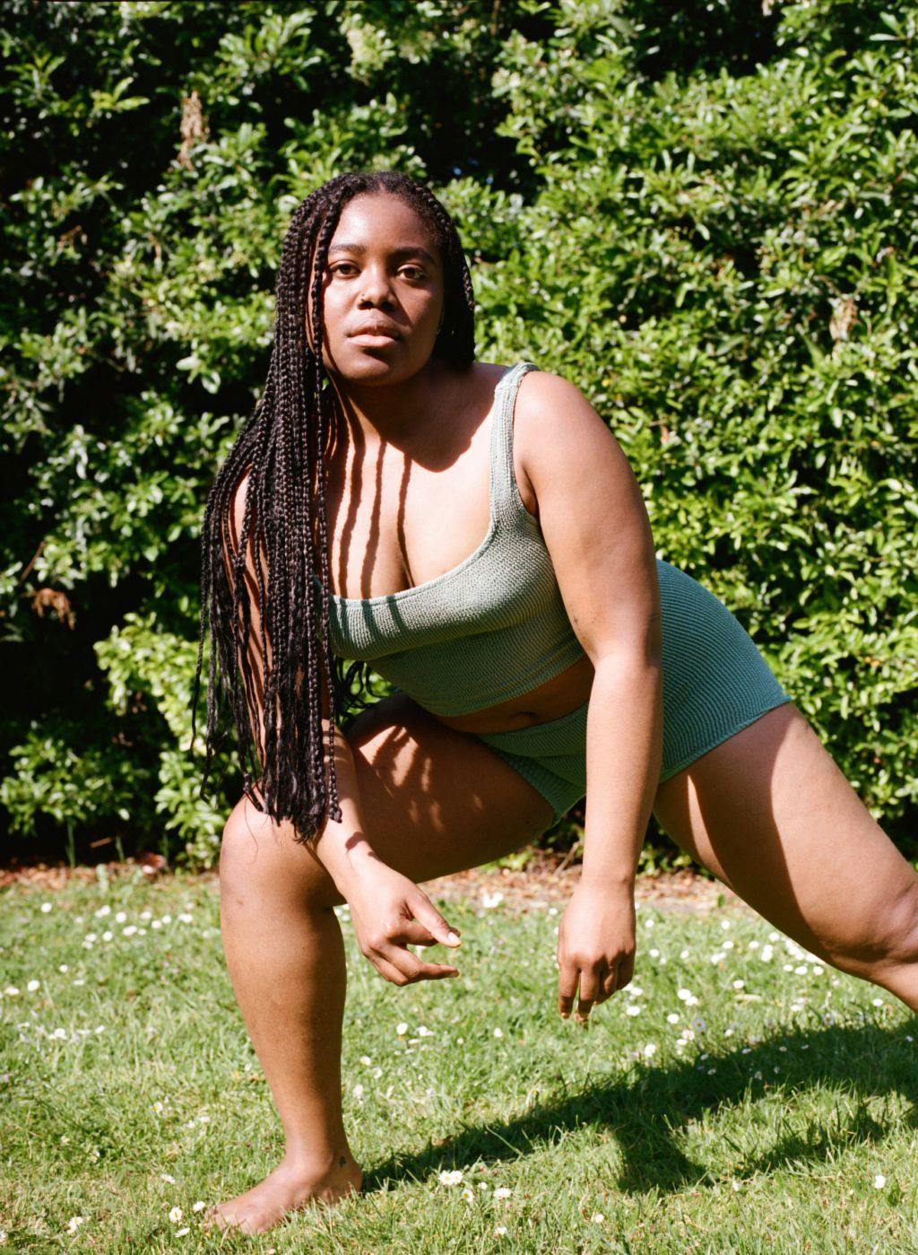 Esther stretching in green swimsuit top and shorts