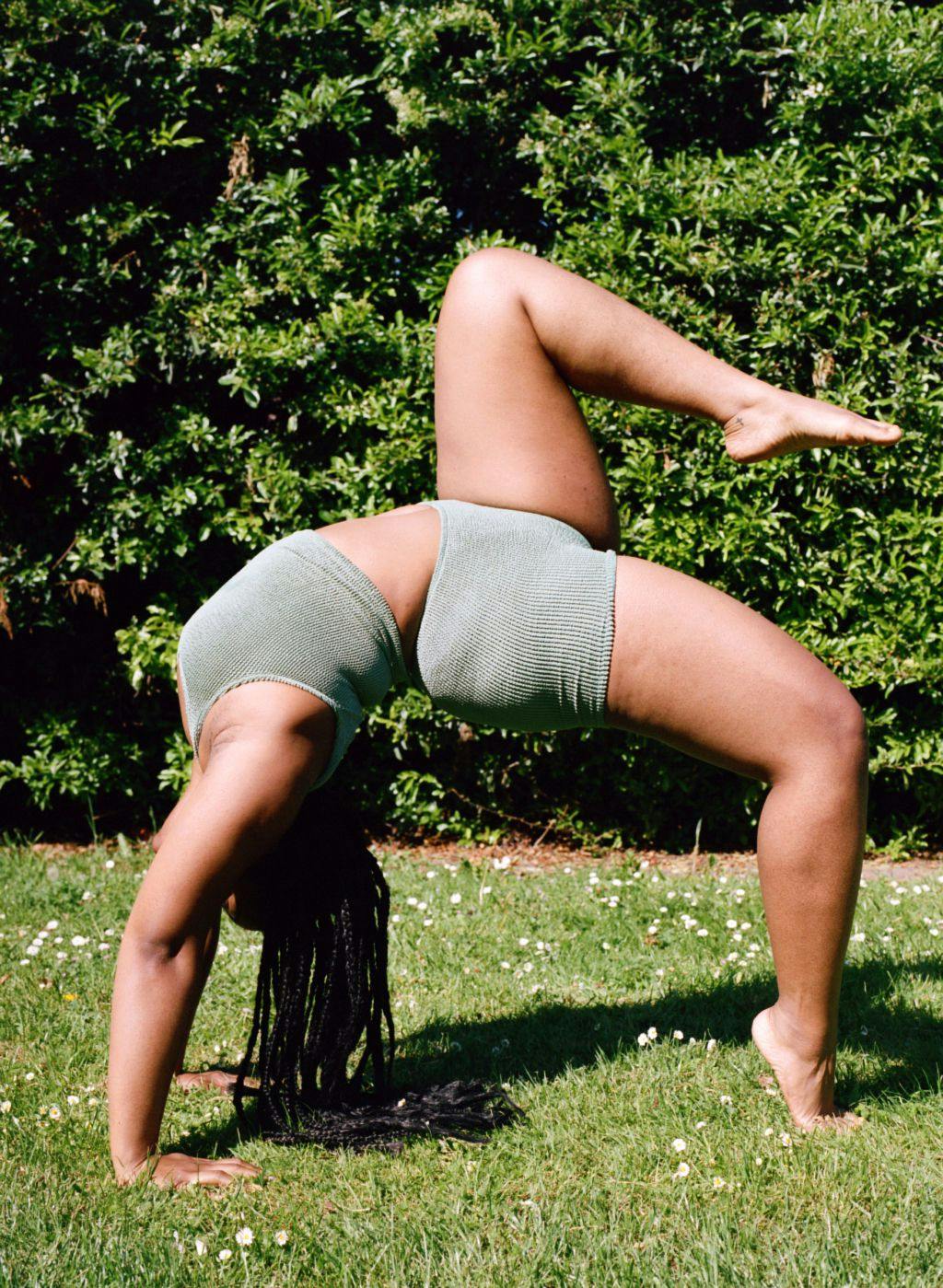 Esther stretching in green swimsuit top and shorts