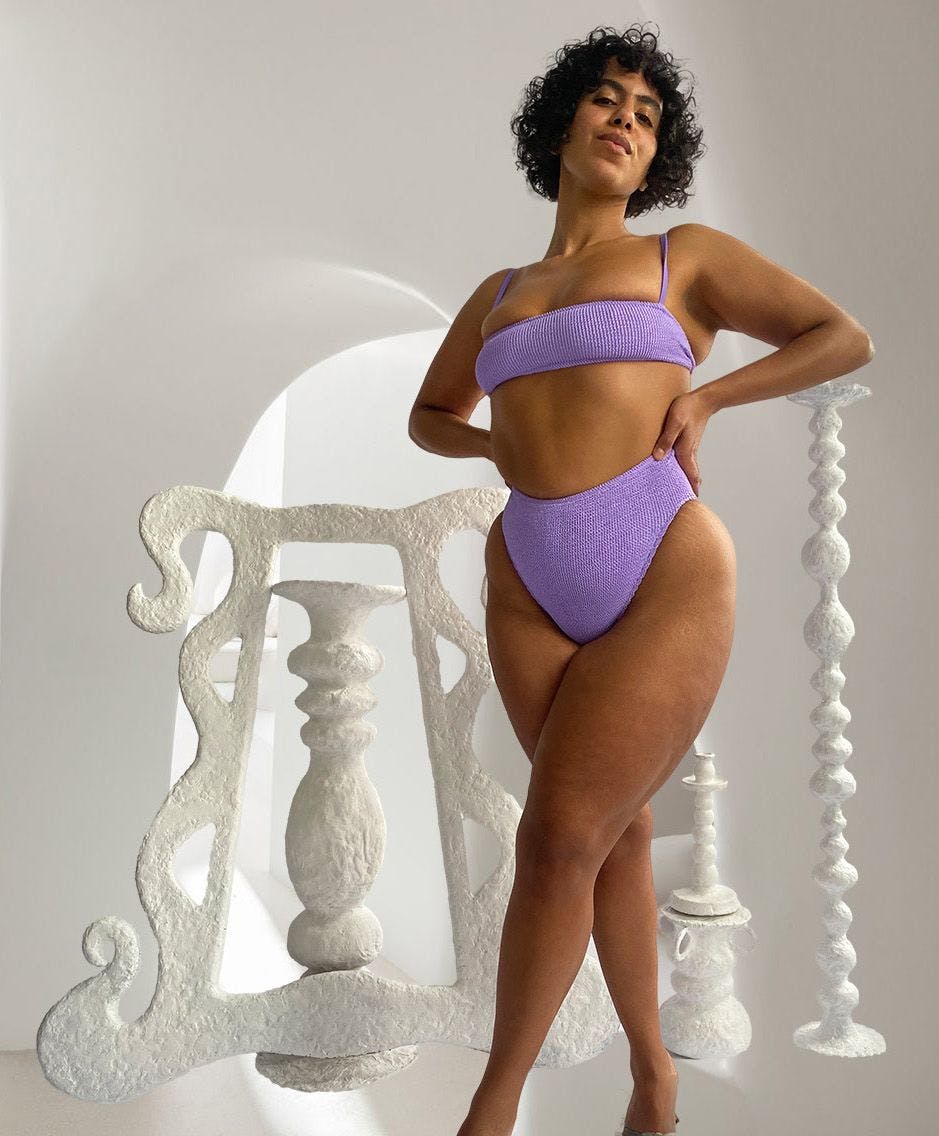 Nadine in lilac bikini with sculptures in the background