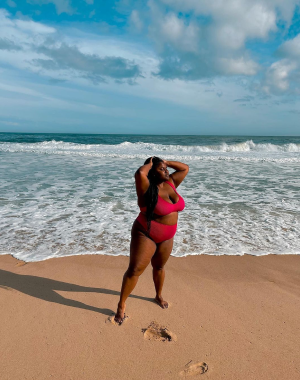 A Black woman standing on the beach